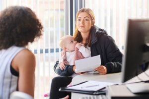 Image of young mother with a baby at an appointment seeking help from a service provider