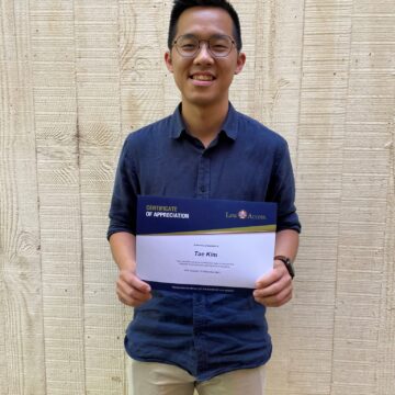 Image of a law student holding his certificate of appreciation